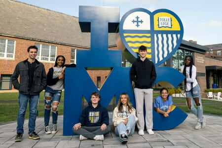 Students standing in front of the I love MC sculpture